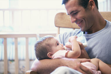 dad feeding baby bottle