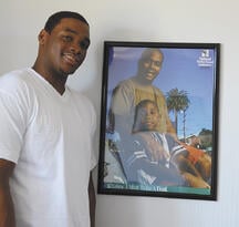 Kyle Parrish stands next to NFI's fatherhood poster.