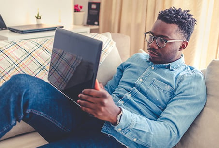 picture of a man on a couch using a laptop